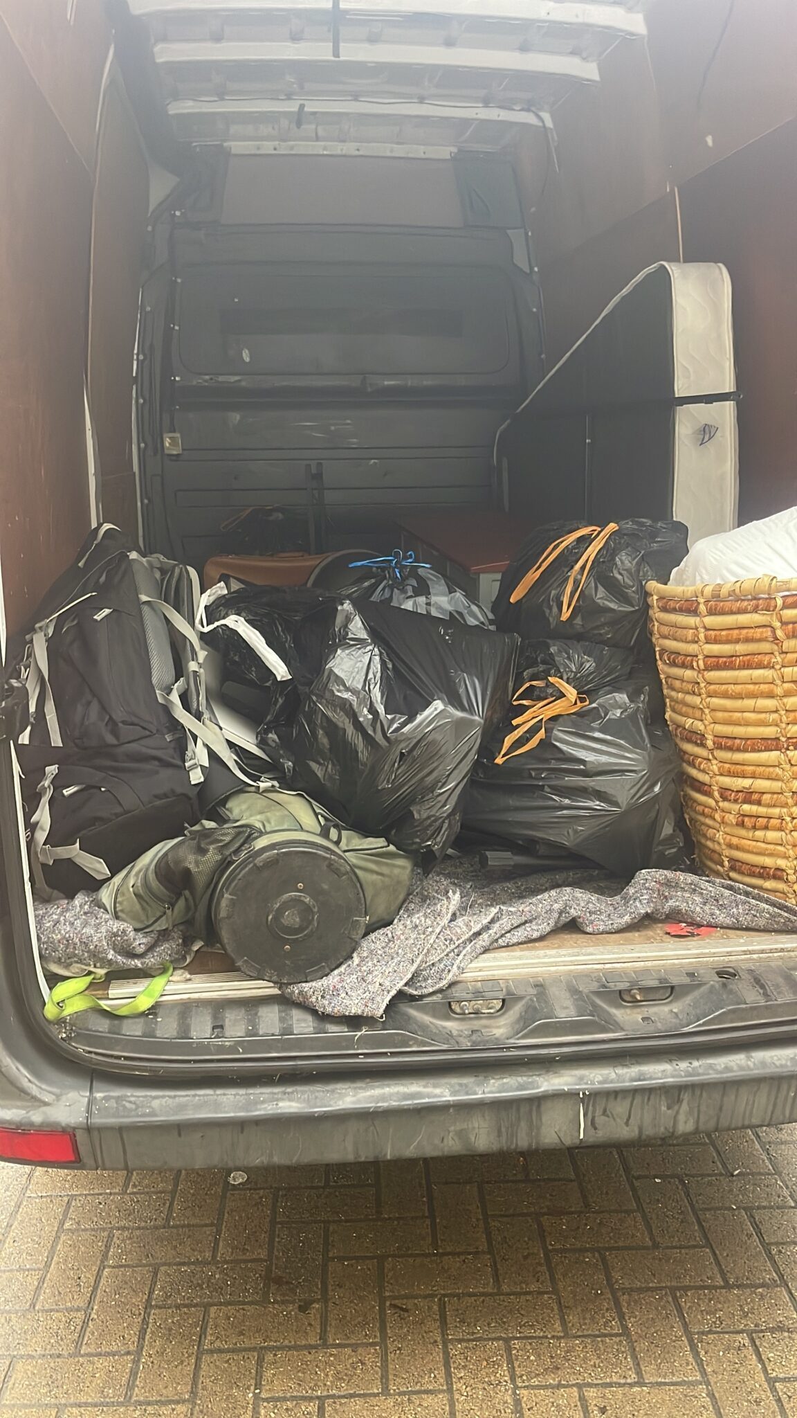 Inside an ESV Removals Sprinter van showing multiple black bin bags and loose items loaded in the rear, illustrating why boxes are better for stacking and protecting belongings during a Brighton or Sussex move.