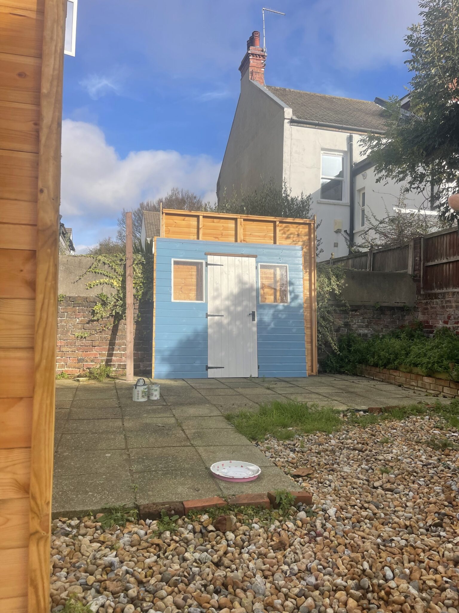 Dismantled blue shed with panels laid out and ready for transport in a Brighton garden
